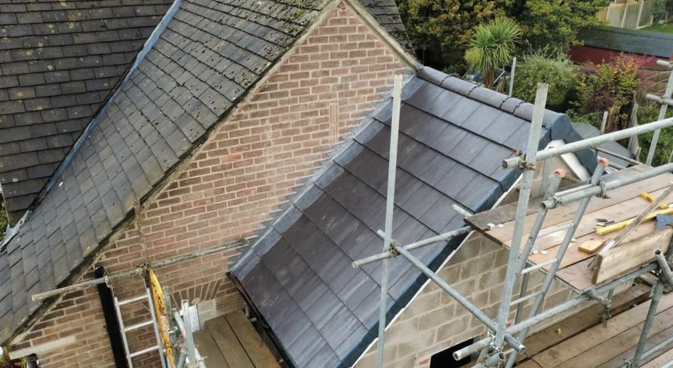 Extension roof in new tiles meeting an older slate roof