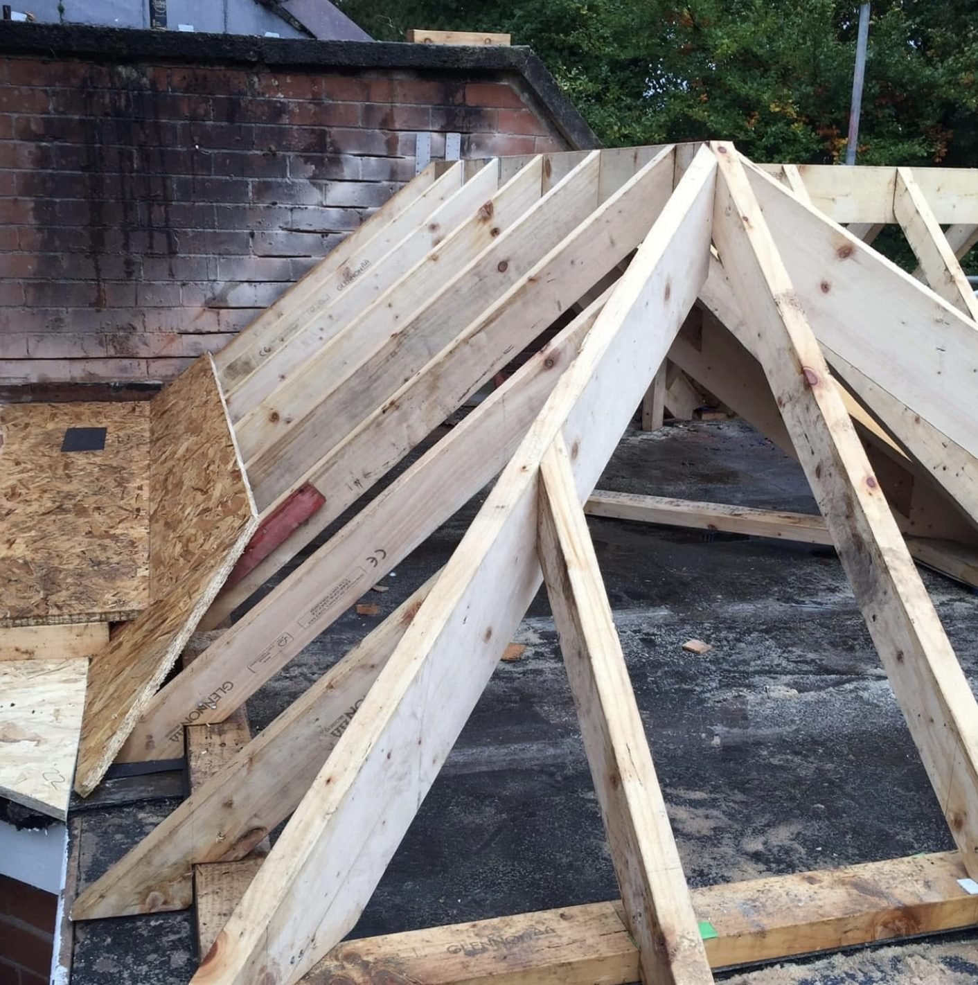 Timber hip roof framed on top of an old flat roof