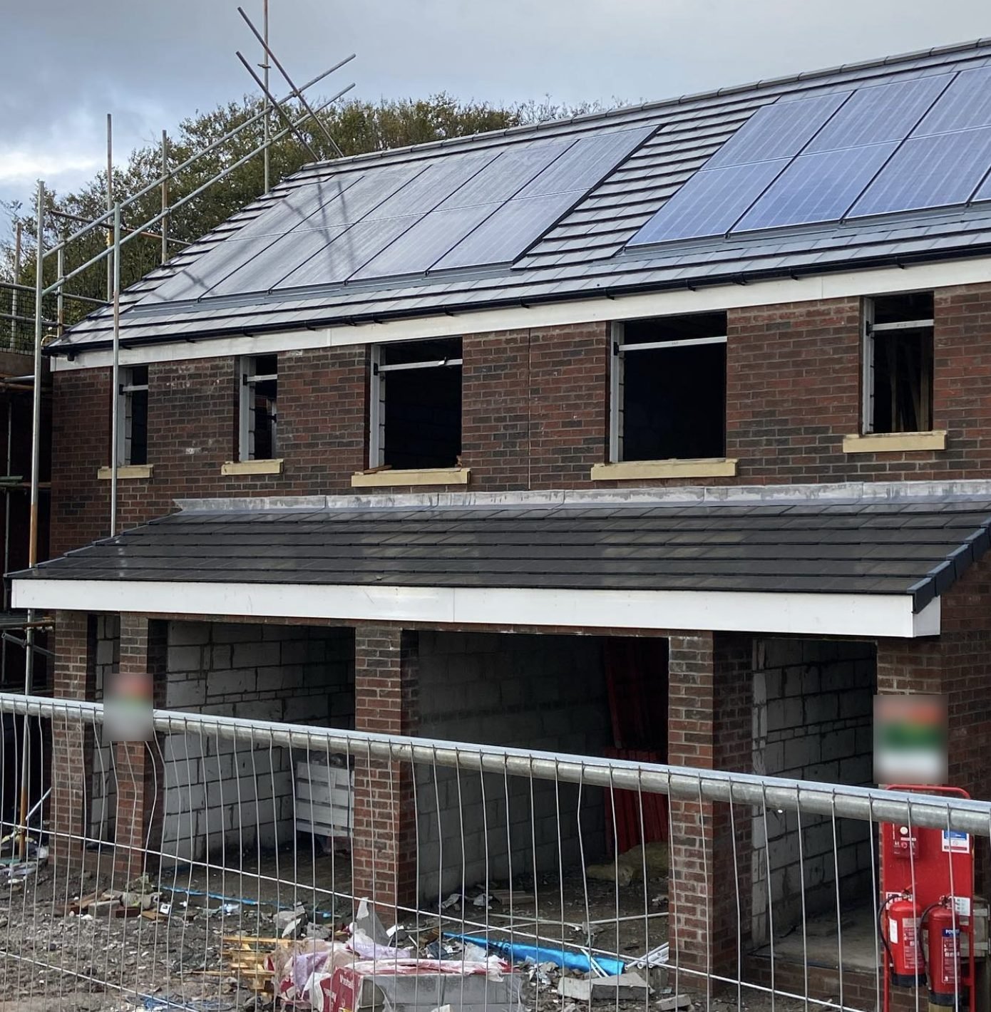 New-build house with a tiled main roof and a tiled garage roof below